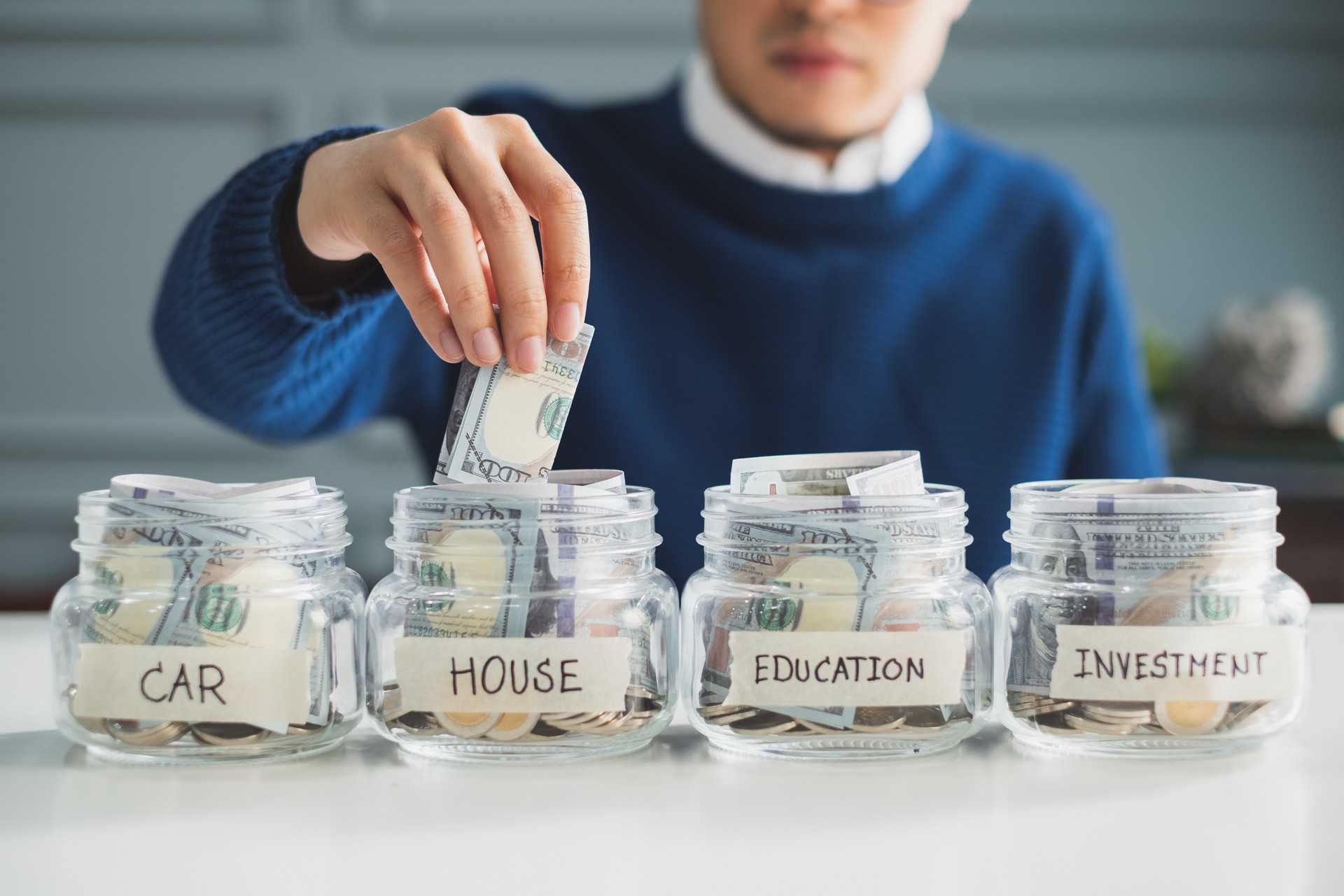 Hand's man putting money in jar for future, money plan, save money and management concept